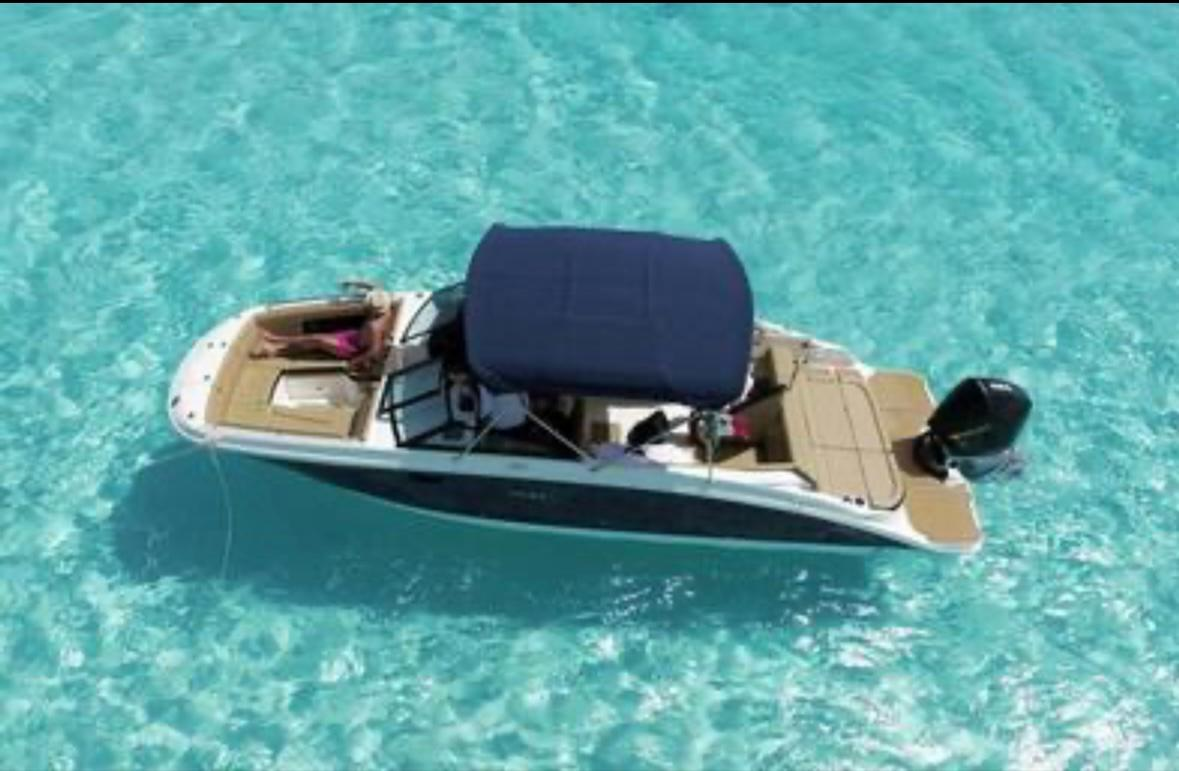 Dash Island Adventures boat floating in clear turquoise Bahamian water